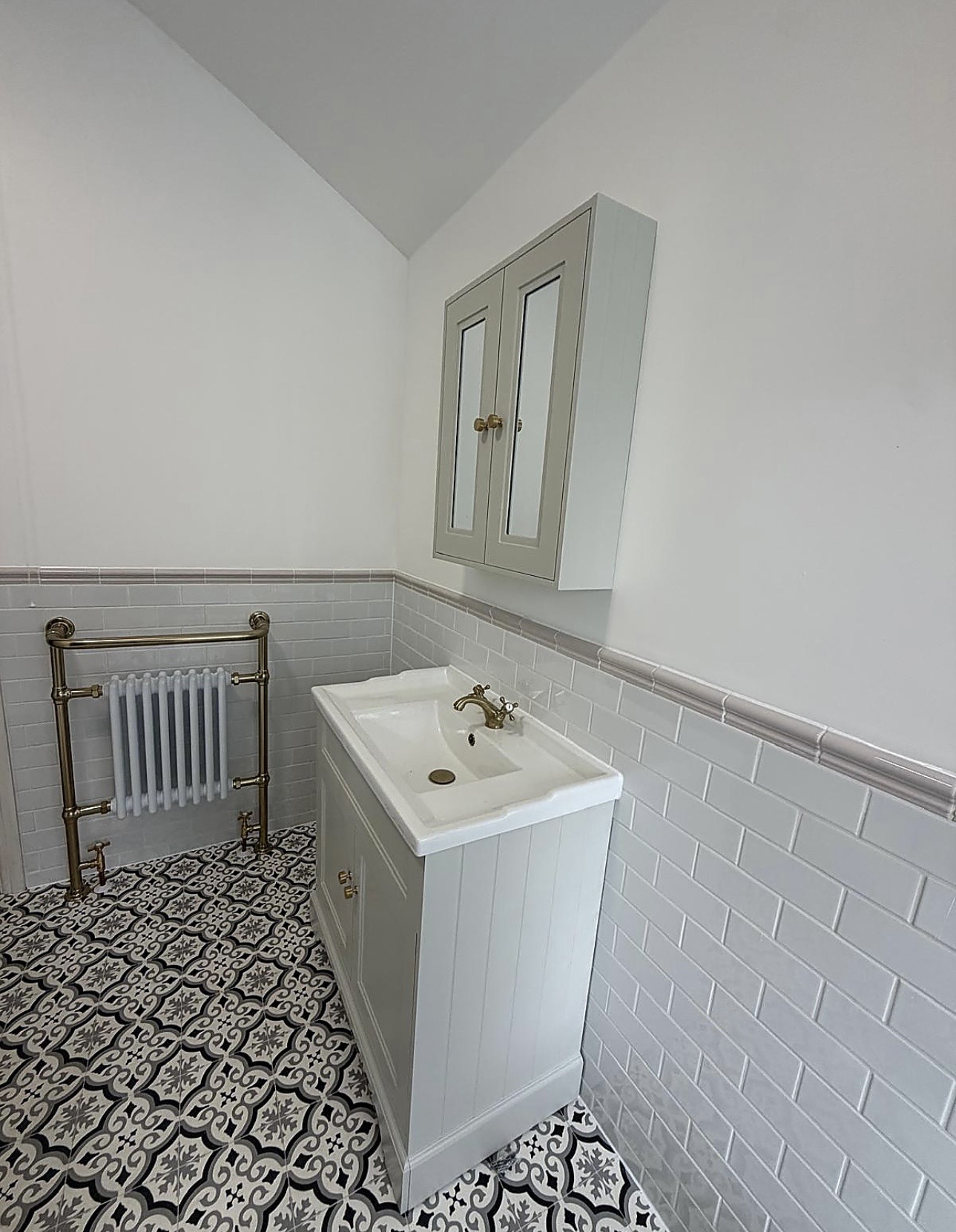 Traditional bathroom vanity, mirrored wall cabinet and brass-framed column radiator installed in B67 by M3 Trades