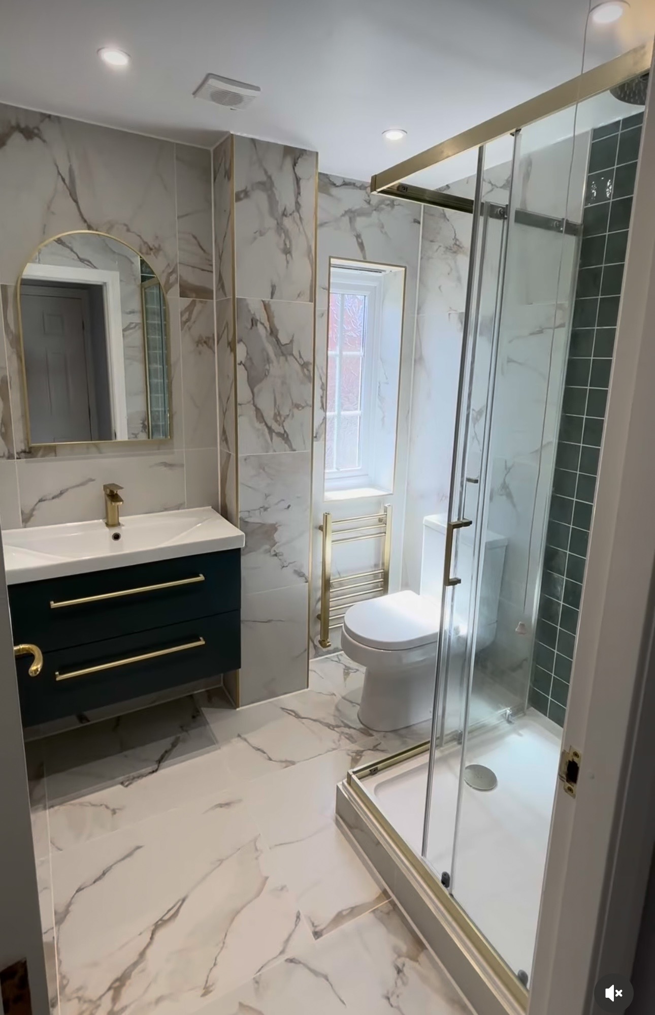 Luxury marble-tiled bathroom with navy vanity and brushed brass fittings, installed by M3 Trades in Stourbridge